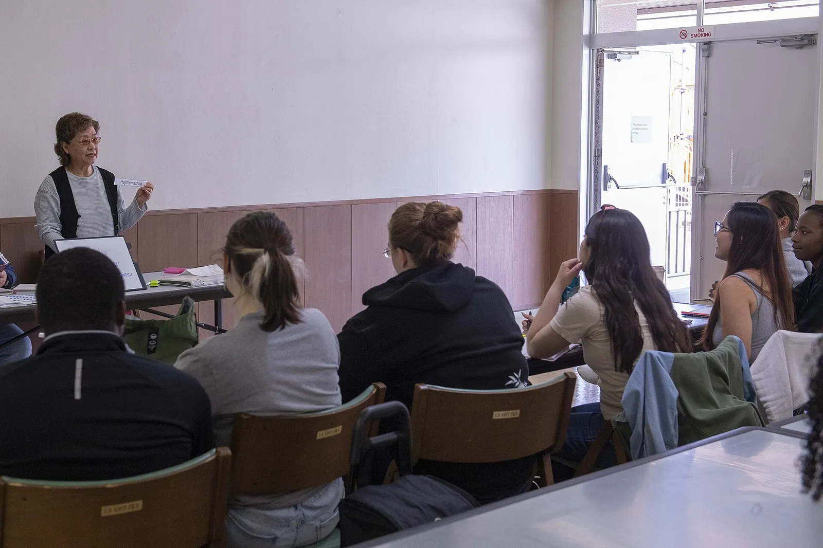 Pengajar kelas Bahasa Jepang memegang kartu perkenalan di depan peserta